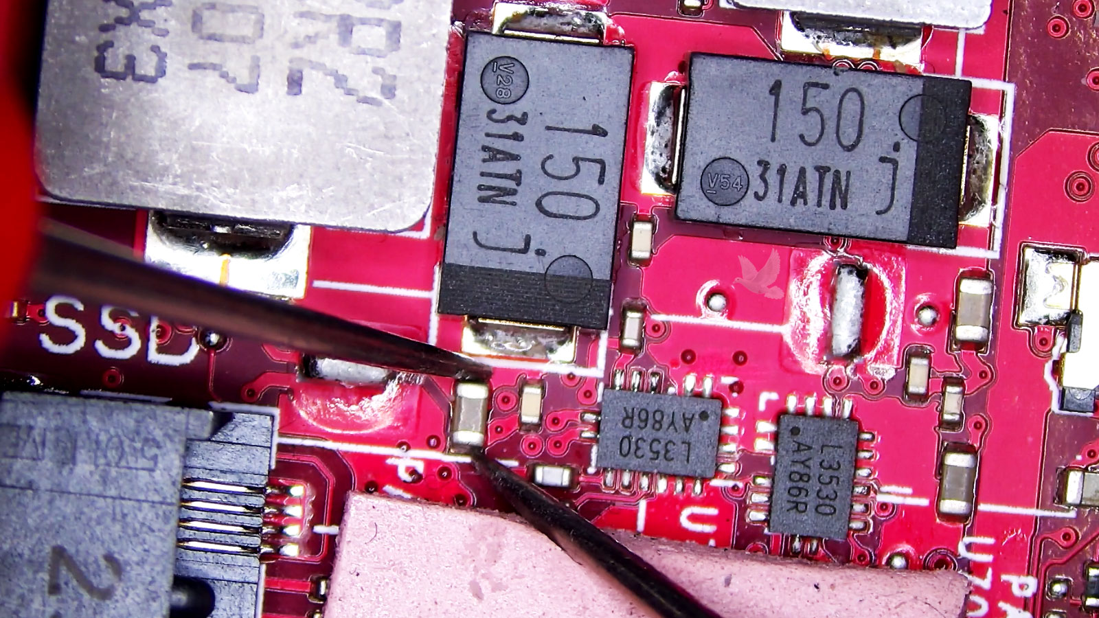 ASUS ROG motherboard undergoing component-level testing with capacitors being measured for electrical shorts