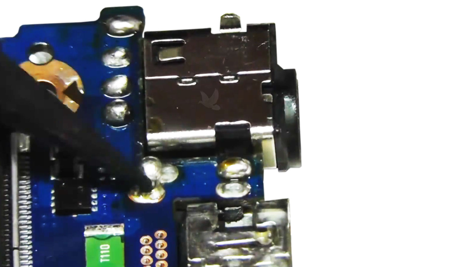 Laptop motherboard DC jack being soldered during power connector replacement