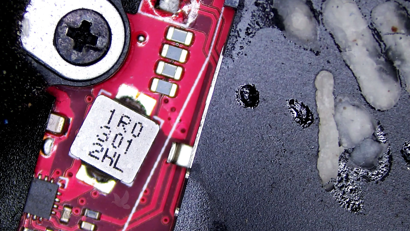 Long-Term-Liquid-Damage-Around-1R0301-2HL-Coil Computer circuit board with liquid damage and white residue surrounding the 1R0301 2HL coil