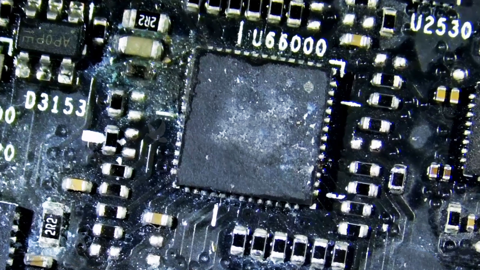 Heavy liquid corrosion affecting an IC chip and surrounding components on a laptop motherboard