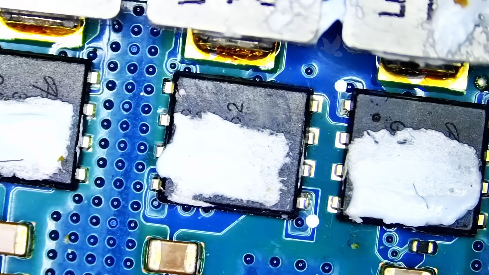 MOSFETs and coils on a computer circuit board protected by thermal pads for heat dissipation