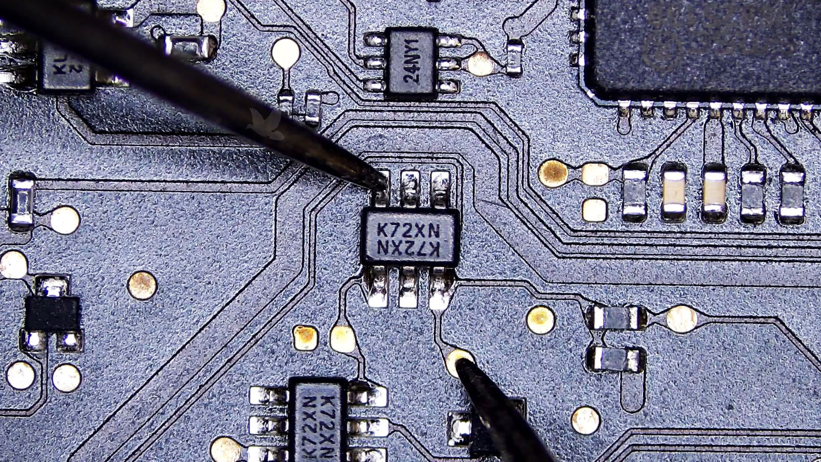 Six-pin K72XN IC being measured during computer circuit diagnosis