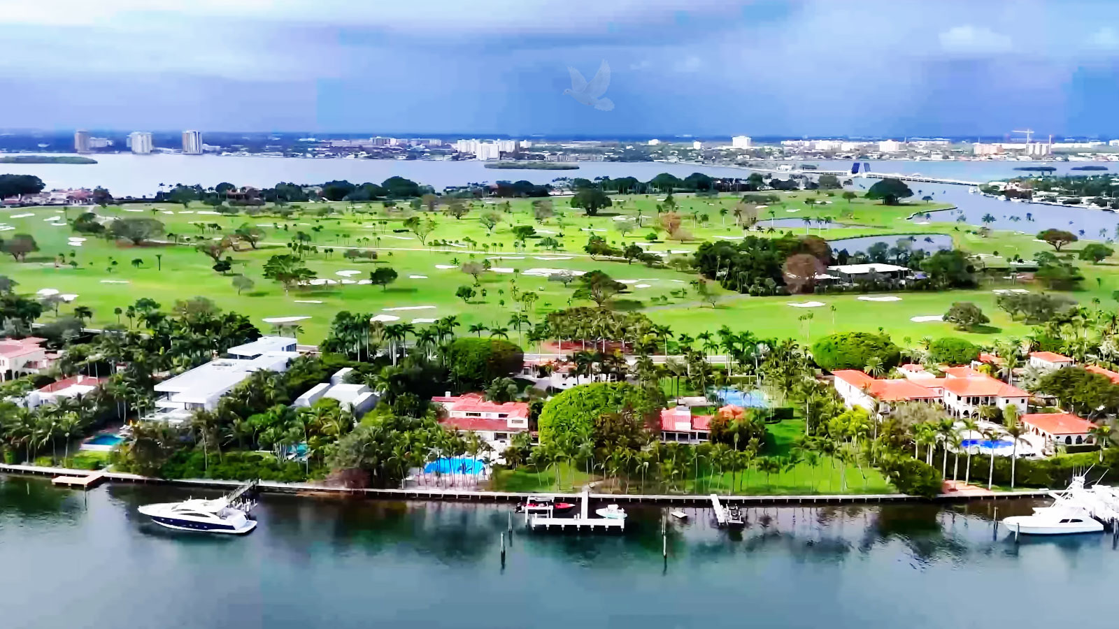 Aerial view of Indian Creek Island with luxury homes, boats, docks, palm trees, and landscaped lawns