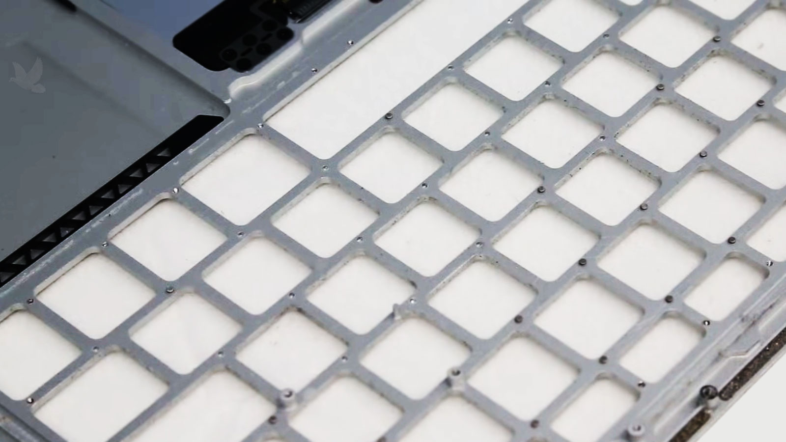 MacBook Air fully disassembled with the old keyboard removed and metal frame exposed