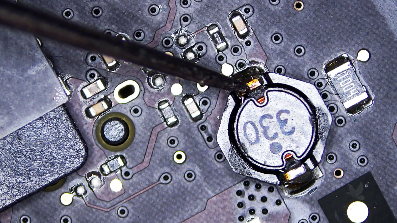 MacBook Air logic board being tested during circuit-level diagnosis