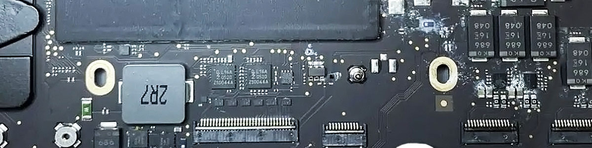 MacBook Pro logic board with corrosion around IC chips and electronic components