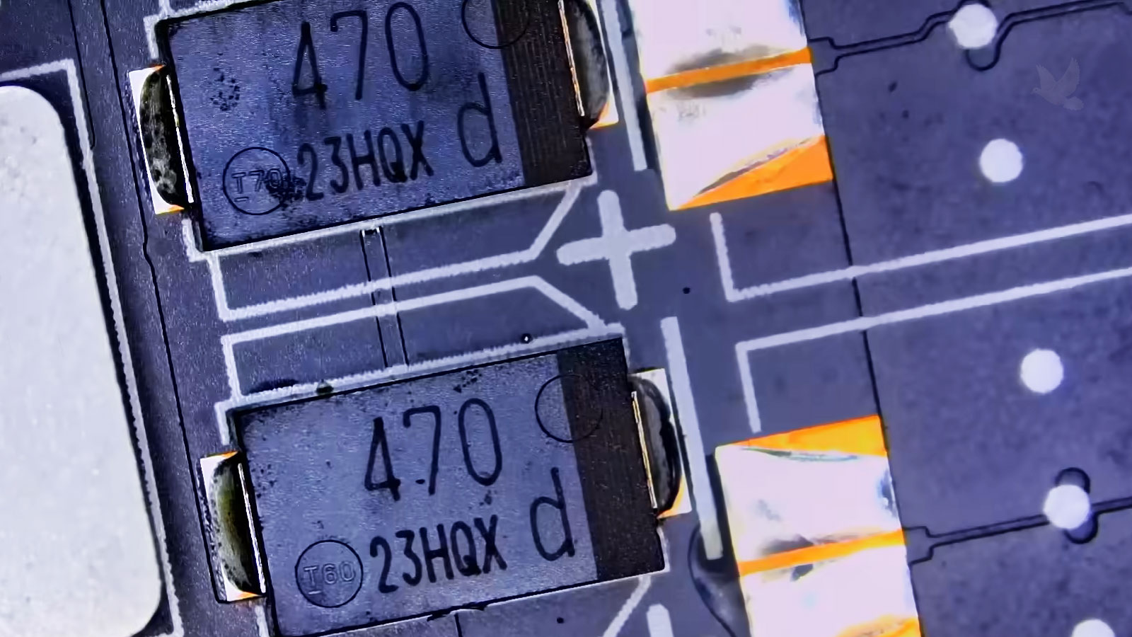 Damaged 470 SMD polymer aluminum electrolytic capacitor on a computer circuit board with slight discoloration
