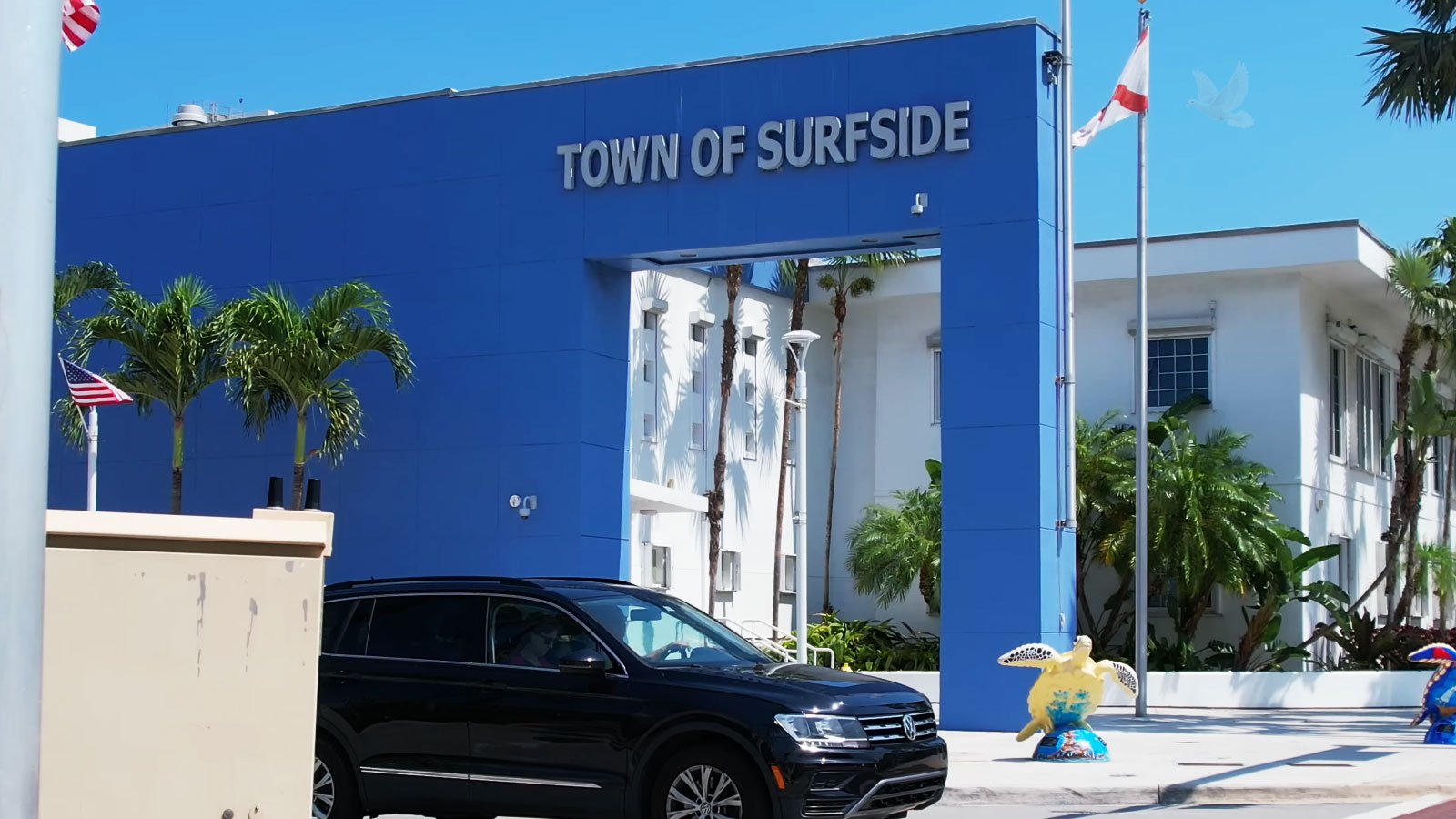 Town of Surfside sign with flags and a sea turtle display