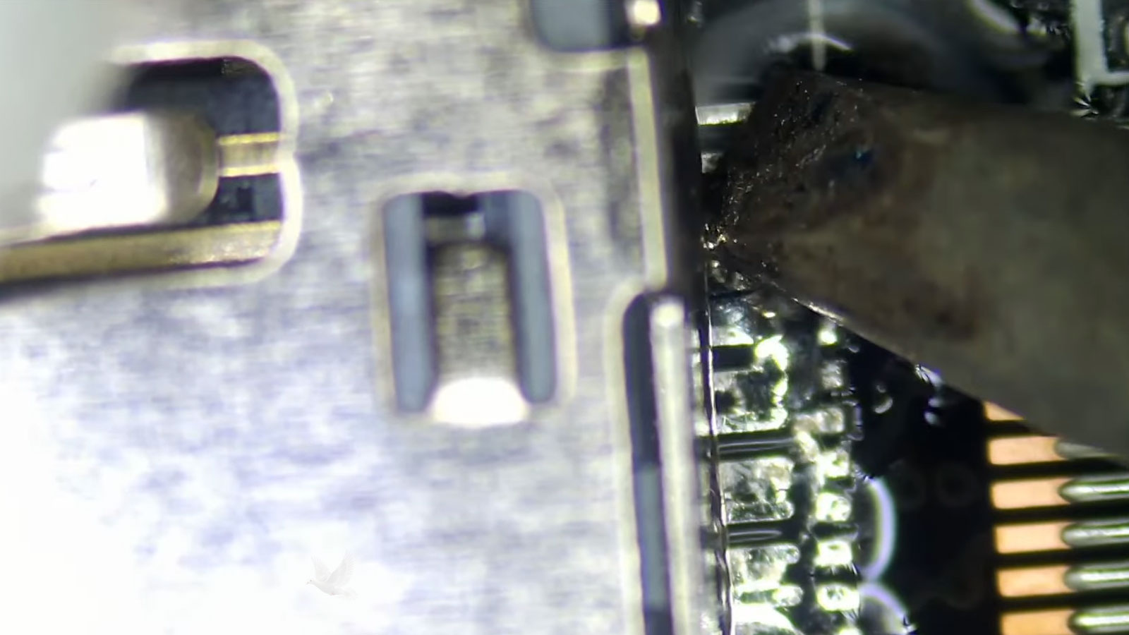Heavy-duty soldering tip removing a metal shield from a computer circuit board