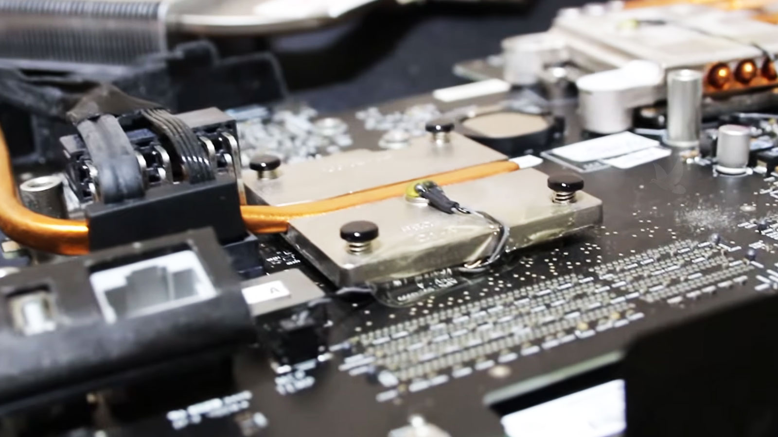 Repaired iMac video card being reassembled with its heatsink and temperature sensor in place