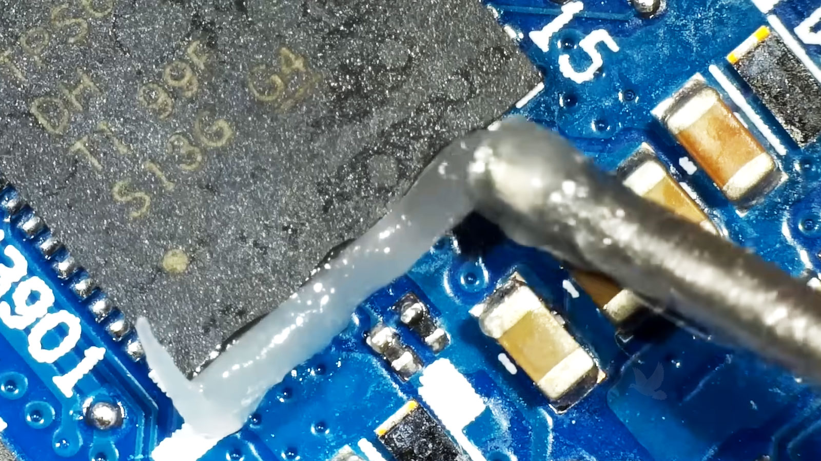 Flux being applied to a chip during laptop motherboard repair