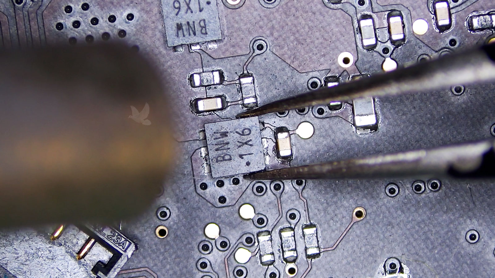 BNW1X6 marked IC being held with tweezers and removed from a computer circuit board using hot air