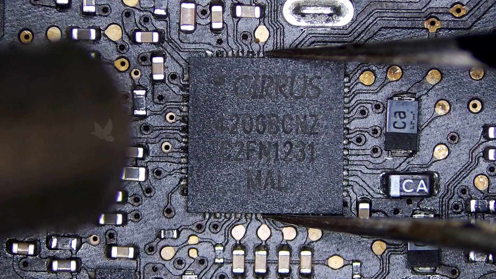 Cirrus IC chip held with tweezers during hot air removal