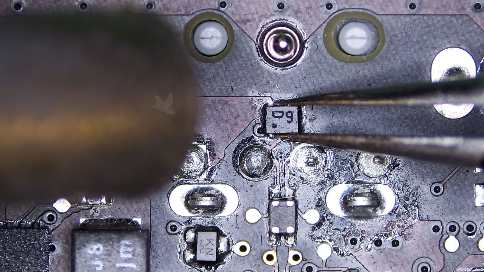 Shorted D9 diode held with tweezers while being removed from a computer circuit board using hot air