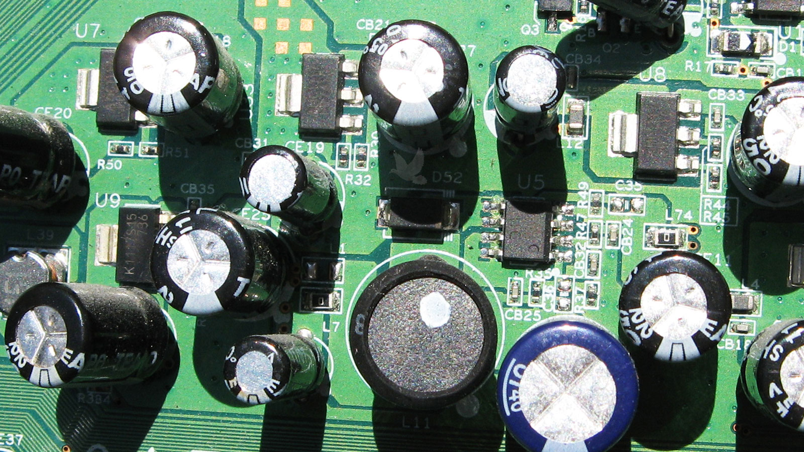 Faulty U5 IC surrounded by capacitors transistors and diodes on circuit board