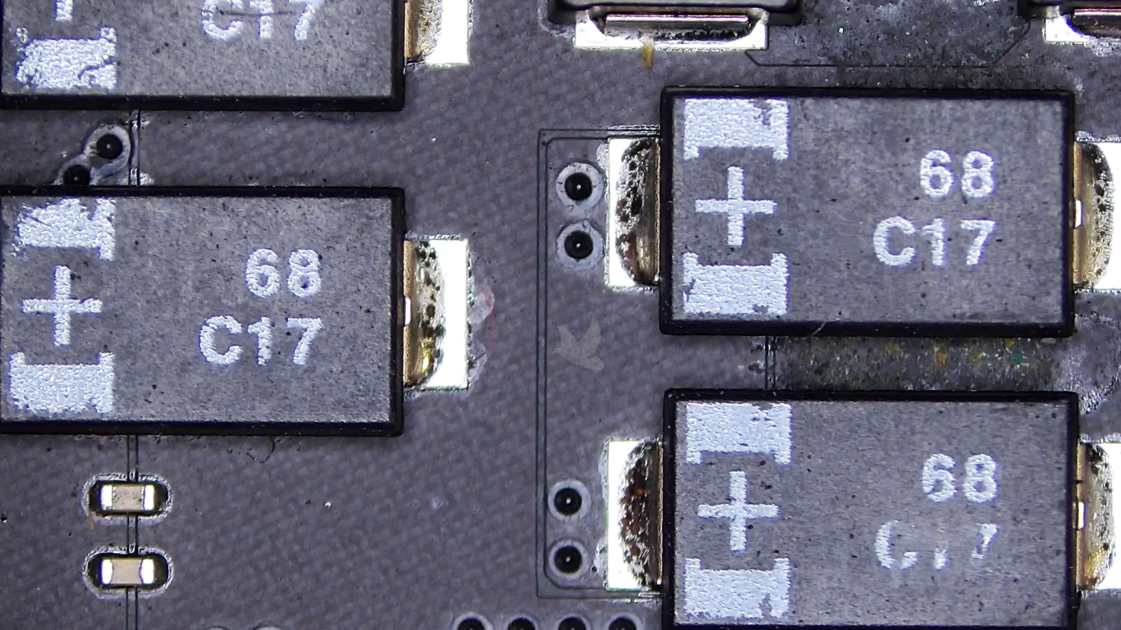 Four C17 capacitors with dried liquid residue between two components