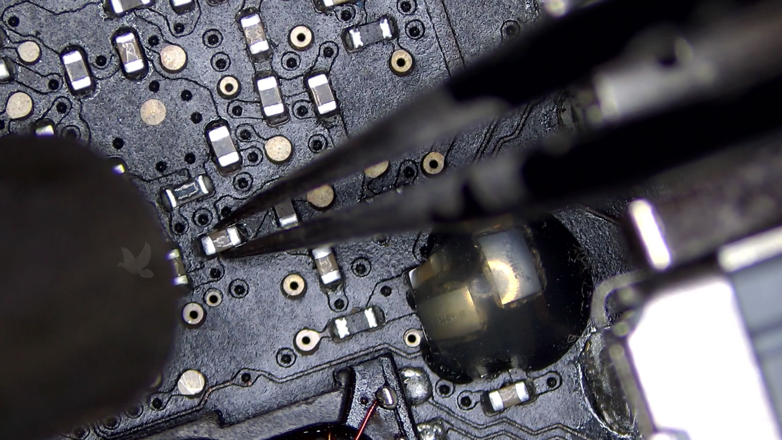 Tiny failed capacitor hidden among surrounding motherboard components after extensive fault tracing