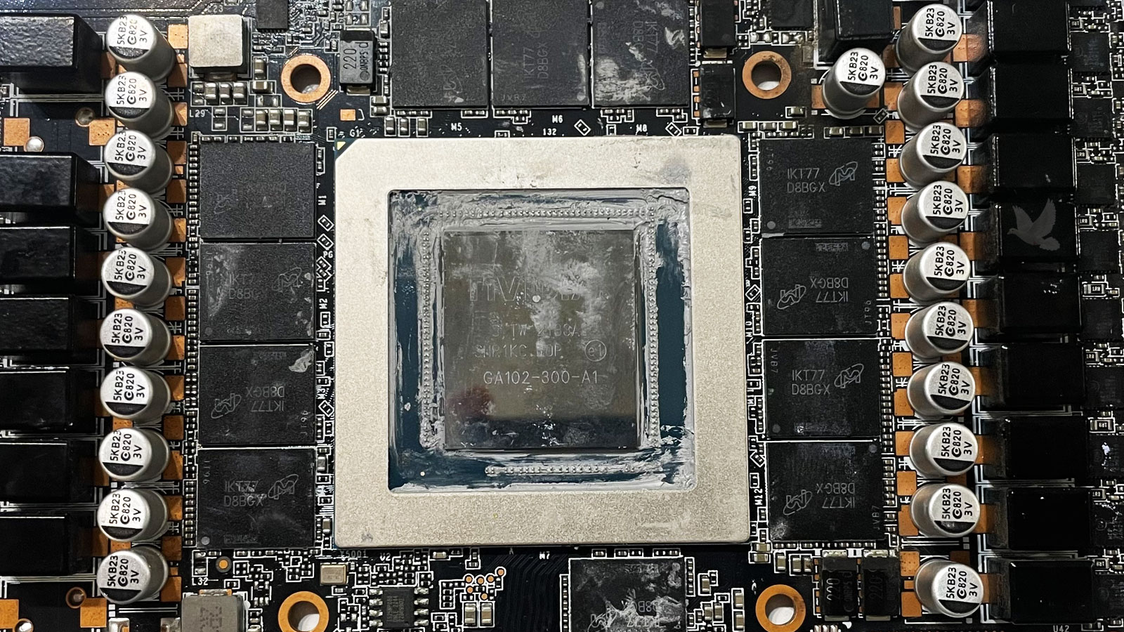 NVIDIA PCIe graphics card with cleaned GPU processor, surrounding memory chips, and a faulty IKT77 D8BGX chip.