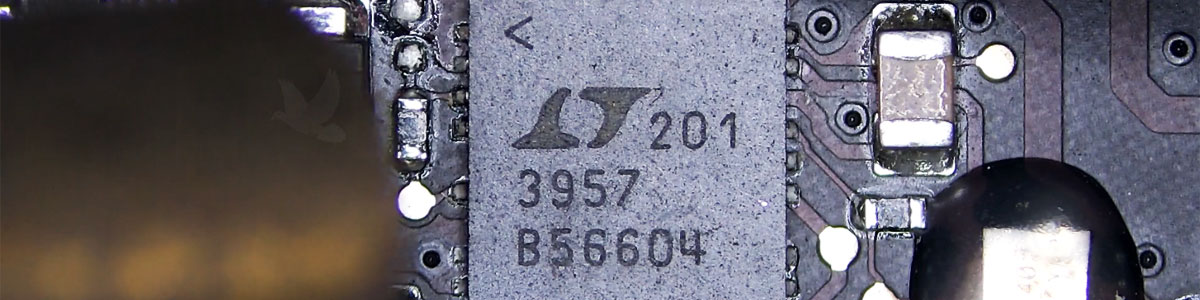 IC chip 201 3957 B56604 being removed with tweezers and hot air during a no-power computer repair