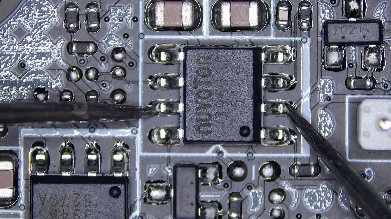 Nuvoton eight-pin chip being measured between pins during motherboard diagnosis