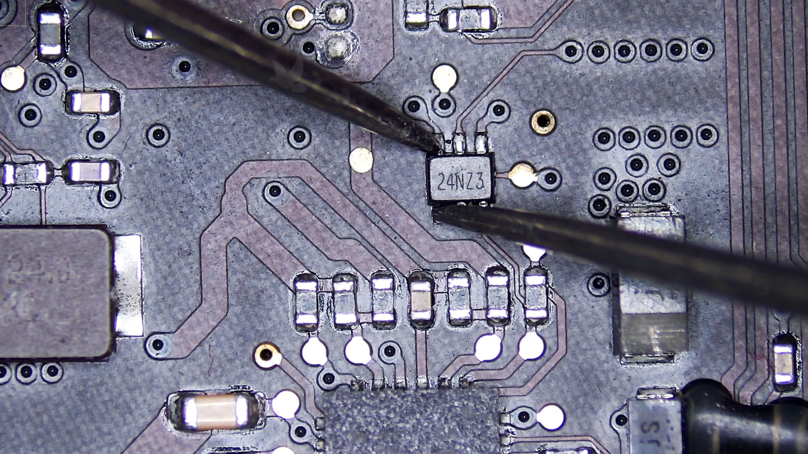 Partially damaged 24NZ3 six-pin IC beside a shorted capacitor on a computer circuit board