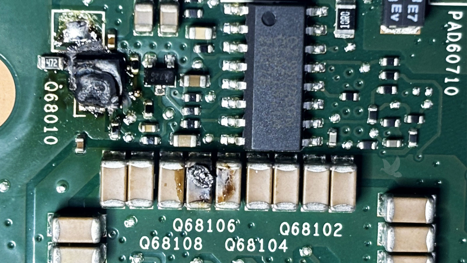 Melted Q68010 component with damaged capacitors on circuit board