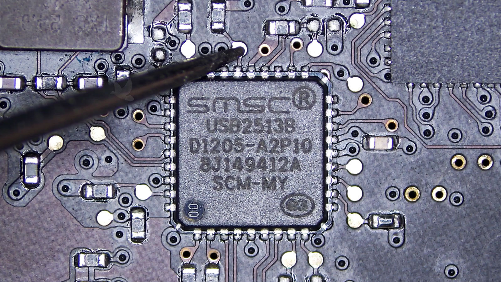 SMSC USB2513B integrated circuit being measured at a pad connected to one of its pins