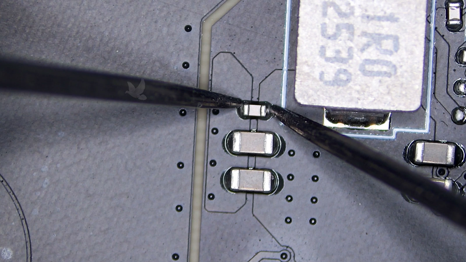 Small failed capacitor surrounded by larger capacitors on circuit board