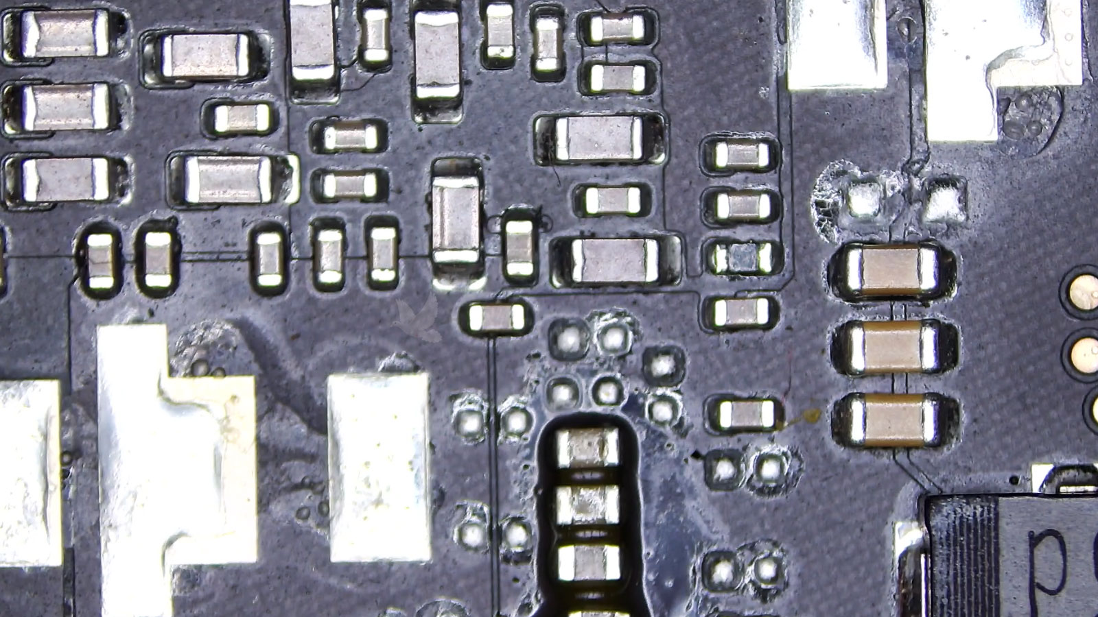Multiple rows of capacitors surrounded by sticky liquid residue on a circuit board