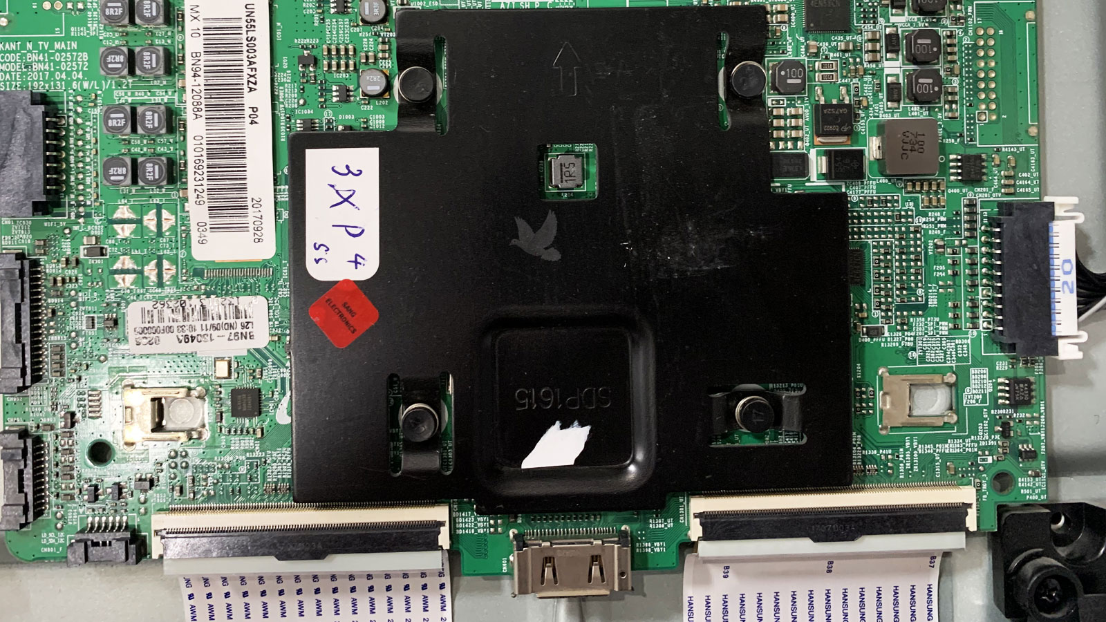 Repaired TV circuit board with a replaced power controller IC located beneath the metal heat sink covering the main processor.
