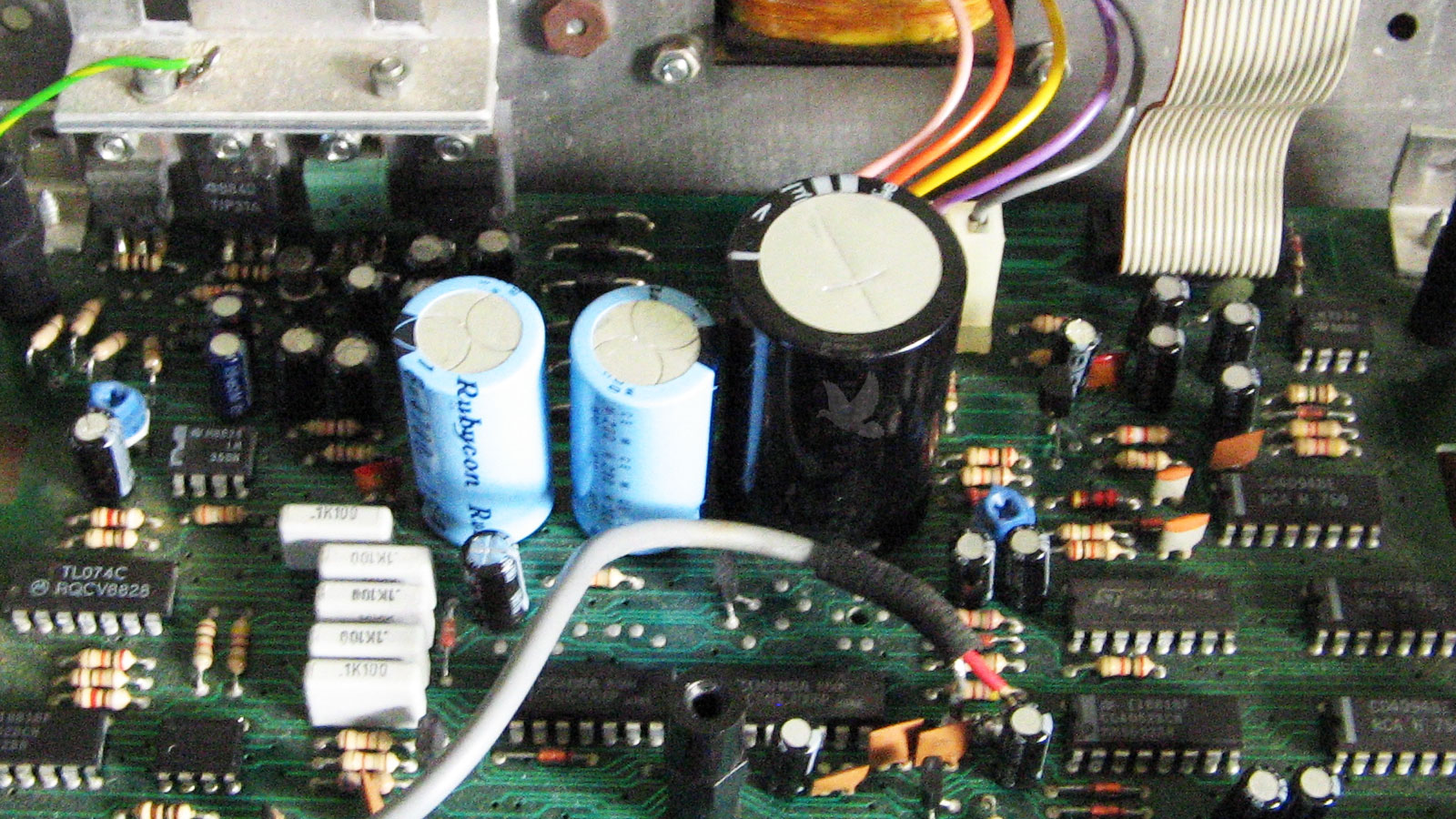 Circuit board showing three newly replaced capacitors following electronic component repair.