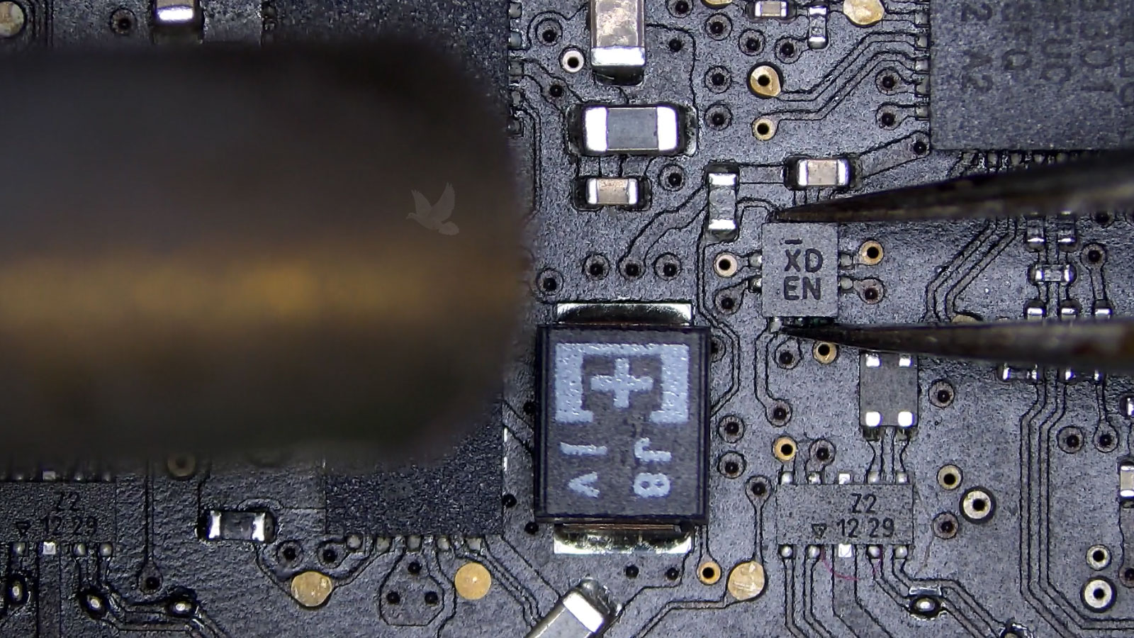 XD EN IC chip held with tweezers during hot air removal